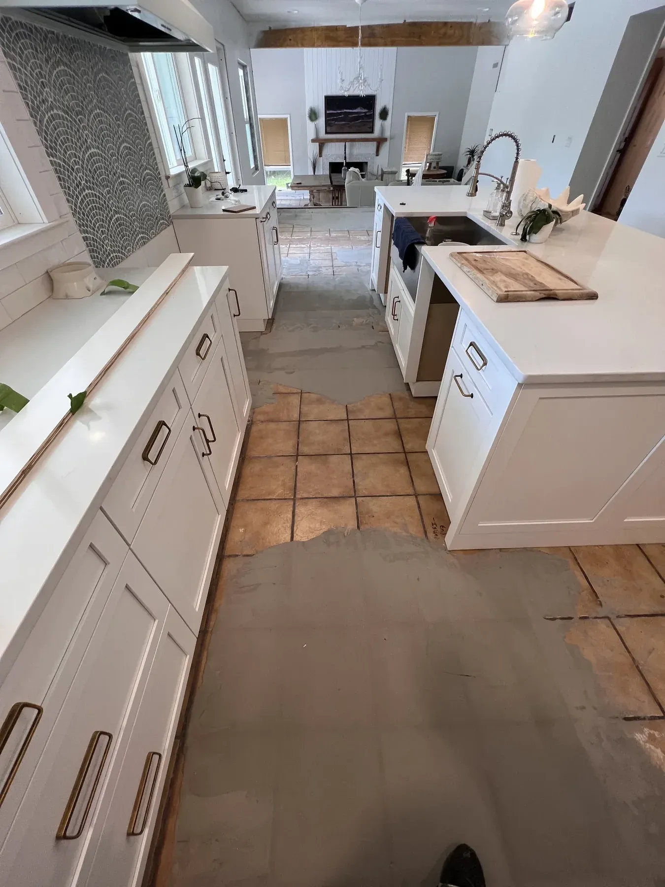 Cocina en Ruskin, Florida, con la cerámica vieja tipo terracota a medio retirar y compuesto nivelador extendido sobre la losa de concreto expuesta