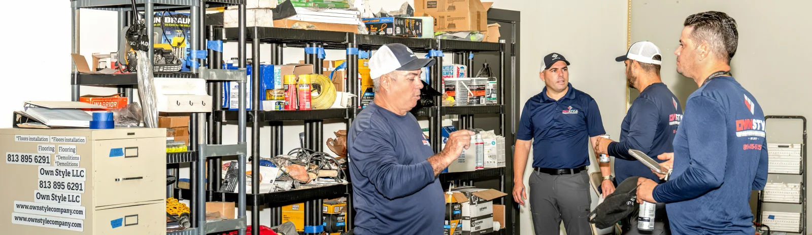 Crew members going over tools and supplies at the warehouse shelves before heading out to a job
